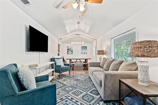 living room with vaulted ceiling, ceiling fan with notable chandelier, and wood-type flooring