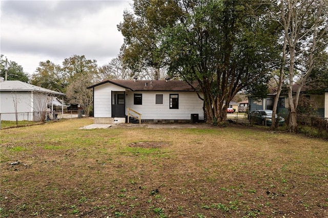 rear view of house with a yard and central AC