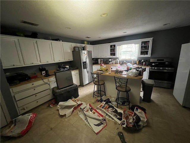 5470 Robert Jefferson Dr E, Theodore, AL 36582 - kitchen with appliances with stainless steel finishes, white cabinets, glass insert cabinets, a kitchen breakfast bar, and a sink