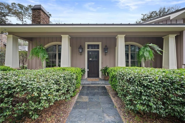 entrance to property featuring board and batten siding and a chimney