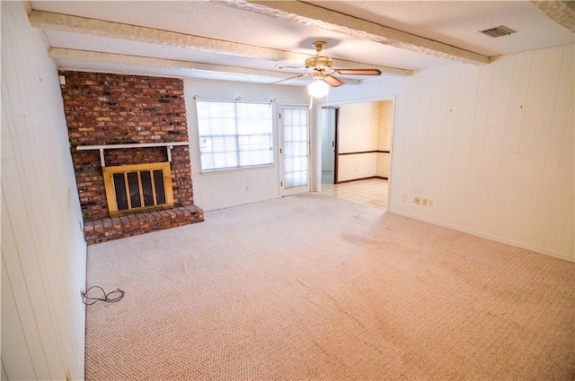 unfurnished living room with ceiling fan, carpet, beam ceiling, and visible vents