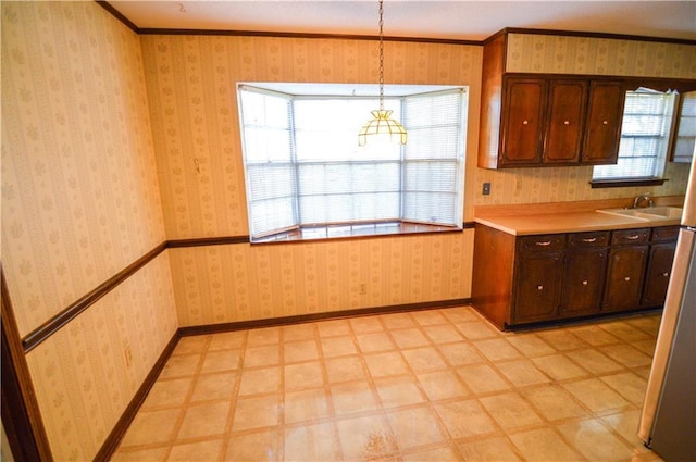 kitchen with light countertops, hanging light fixtures, a sink, and light floors