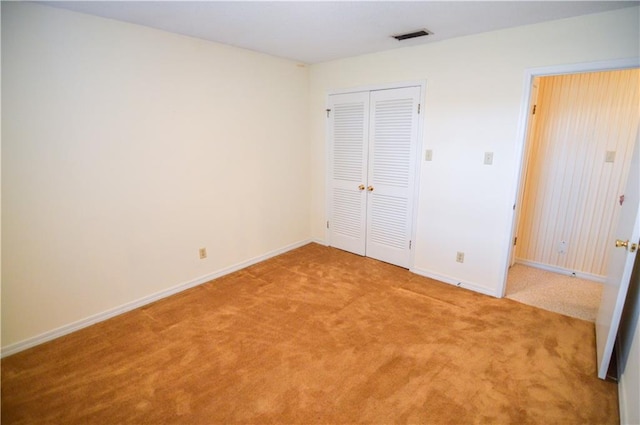 unfurnished bedroom featuring visible vents, baseboards, carpet floors, and a closet