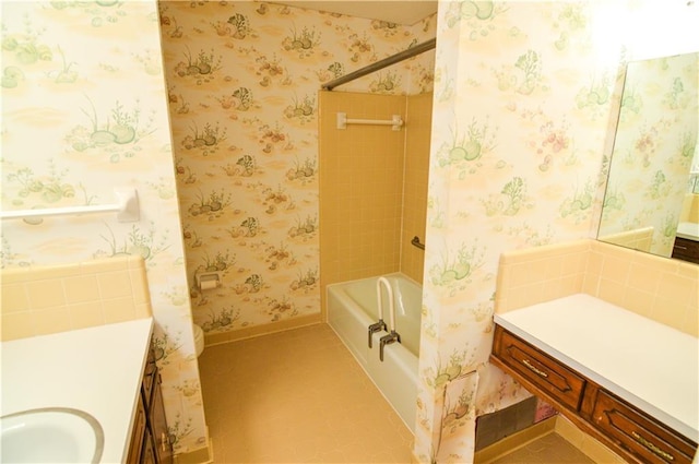 full bath with vanity, baseboards, wallpapered walls, and shower / tub combo