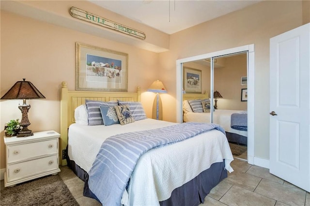 bedroom featuring tile patterned flooring, a closet, and baseboards