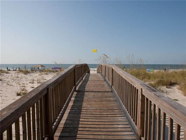 view of home's community with a water view and a beach view