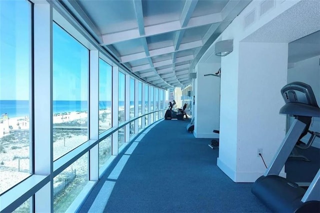 hallway with baseboards, a water view, visible vents, and floor to ceiling windows