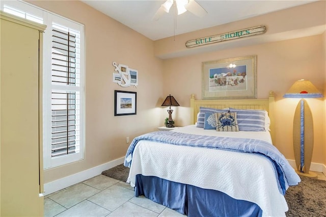 tiled bedroom featuring ceiling fan and baseboards