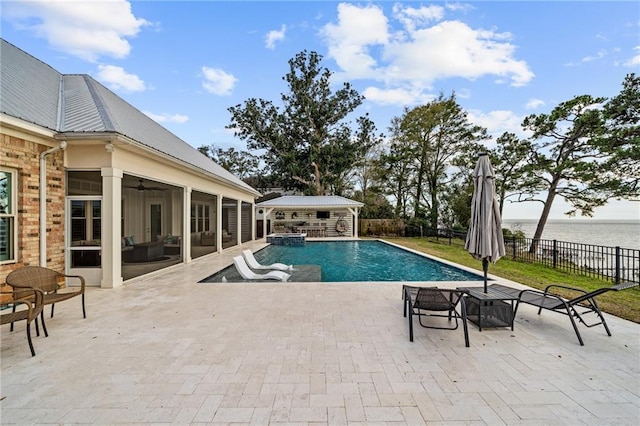 view of pool featuring a water view, a patio area, and a sunroom