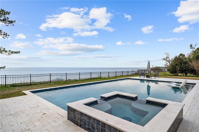 view of pool with an in ground hot tub, a patio, and a water view