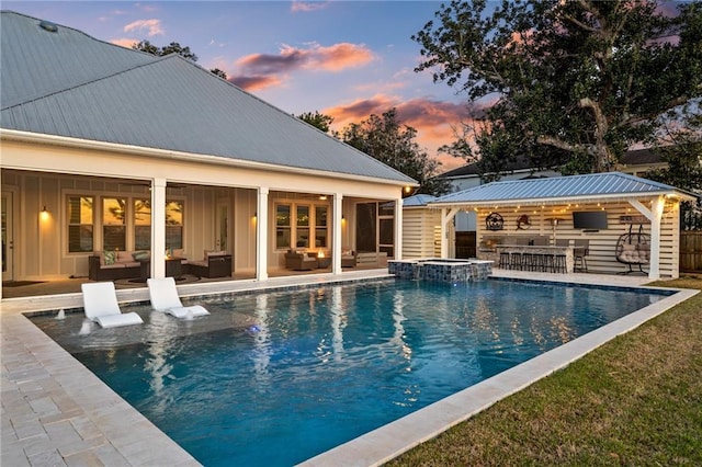 pool at dusk featuring a yard and a patio area