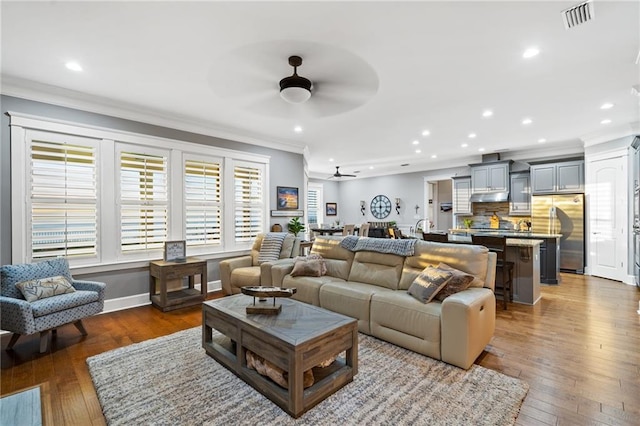 living room featuring crown molding, ceiling fan, and hardwood / wood-style flooring