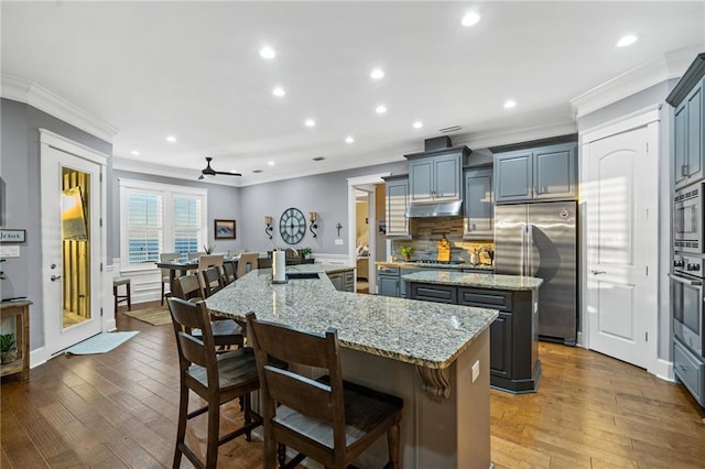 kitchen featuring a center island, ceiling fan, built in appliances, and light hardwood / wood-style floors