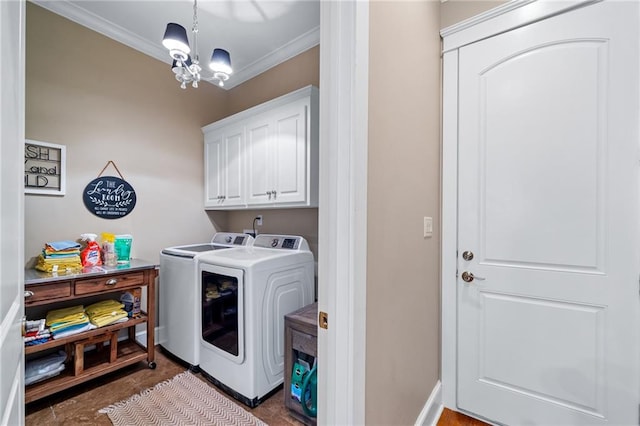 laundry room featuring washing machine and clothes dryer, cabinets, a notable chandelier, and crown molding