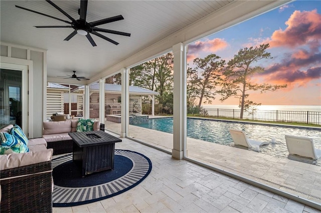 sunroom / solarium featuring a water view and ceiling fan