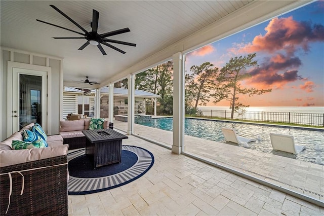 sunroom / solarium featuring a water view and ceiling fan