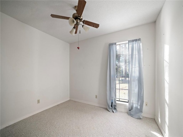 carpeted spare room featuring ceiling fan and a textured ceiling