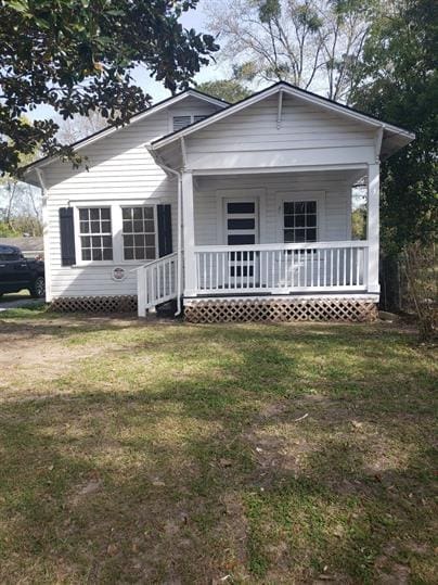 bungalow-style home with covered porch and a front lawn