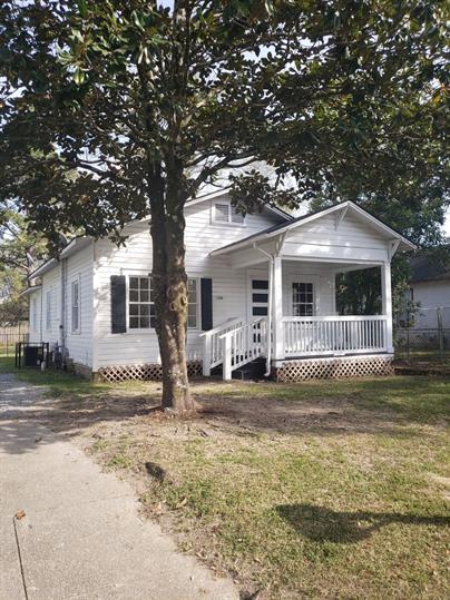 view of front of property featuring covered porch and a front yard