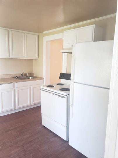 kitchen with white appliances, dark wood-style flooring, range hood, white cabinetry, and a sink