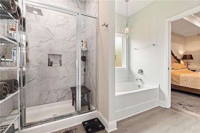 bathroom with hardwood / wood-style flooring and separate shower and tub