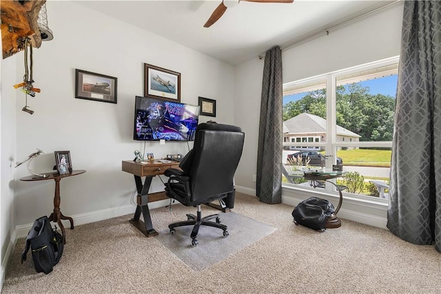 carpeted office space featuring ceiling fan