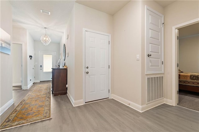 entryway featuring hardwood / wood-style floors and a notable chandelier