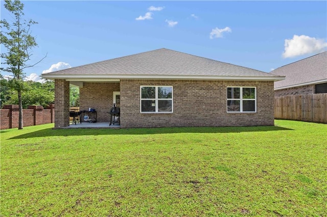 back of property with a patio area and a lawn