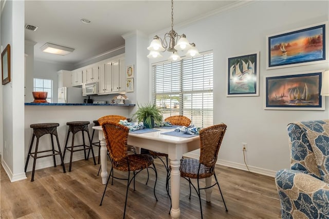50 Forney Johnston Dr Unit 7A, Dauphin Island, AL 36528 - dining space featuring baseboards, wood finished floors, visible vents, and ornamental molding