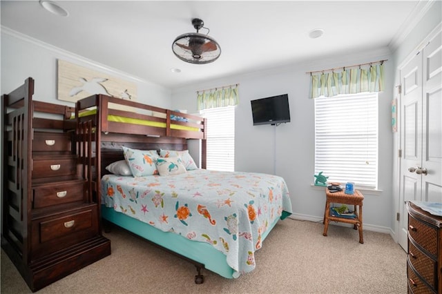 carpeted bedroom featuring a closet and crown molding