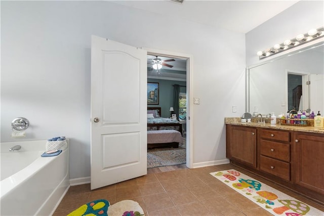 bathroom with tile patterned flooring, a bathing tub, vanity, ceiling fan, and ornamental molding