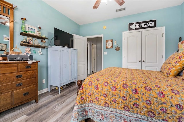 bedroom with ceiling fan, light hardwood / wood-style floors, and a closet