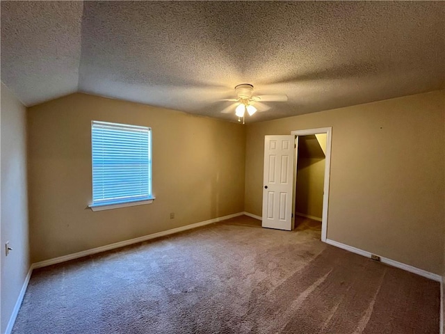 unfurnished bedroom with a textured ceiling, lofted ceiling, ceiling fan, and carpet floors