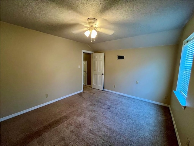 carpeted empty room with lofted ceiling, a textured ceiling, and ceiling fan