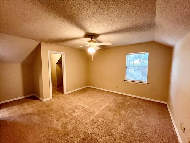 bonus room with lofted ceiling, a textured ceiling, carpet floors, and ceiling fan