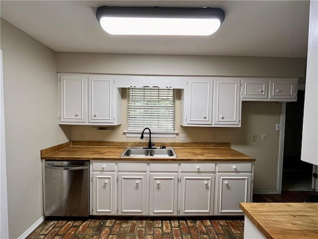 kitchen featuring dishwasher, butcher block countertops, white cabinetry, and sink