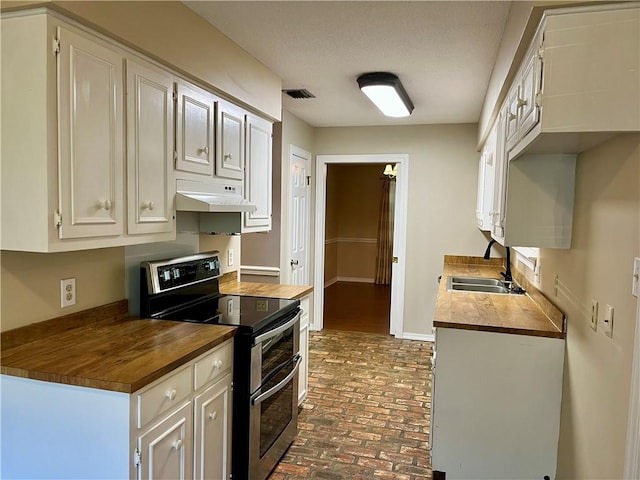 kitchen featuring white cabinets, butcher block counters, sink, and double oven range