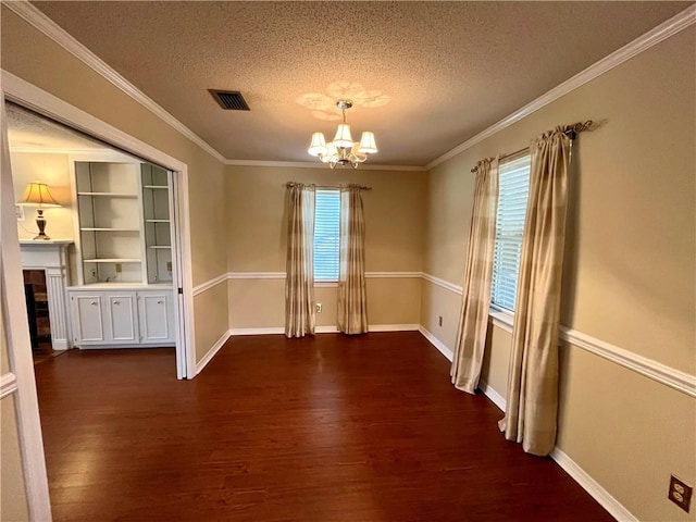 unfurnished dining area with a wealth of natural light, a textured ceiling, dark wood-type flooring, and crown molding