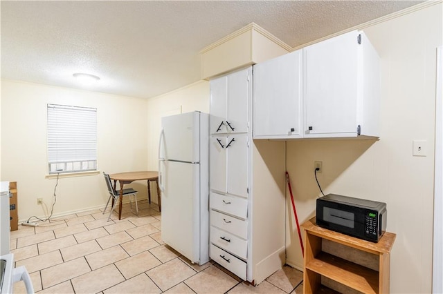 kitchen featuring white cabinets, white refrigerator, and a textured ceiling