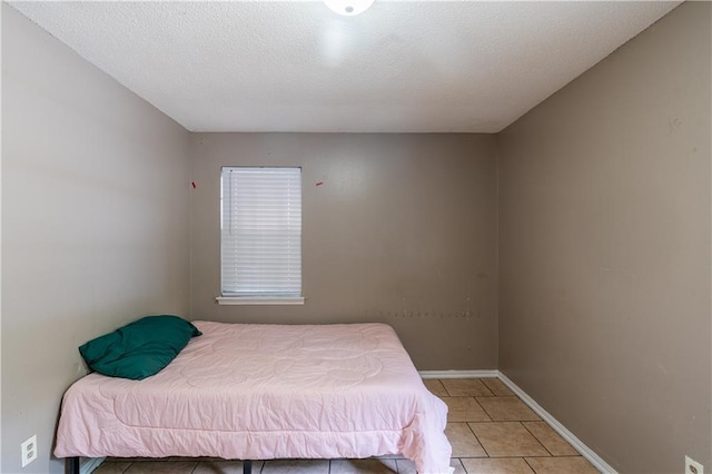 tiled bedroom featuring a textured ceiling