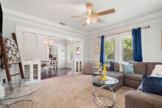living room featuring carpet floors, visible vents, crown molding, and ceiling fan with notable chandelier