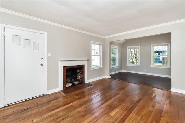 unfurnished living room with hardwood / wood-style flooring, ornamental molding, and a wealth of natural light