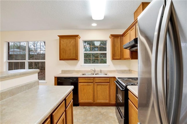 kitchen featuring plenty of natural light, sink, a textured ceiling, and black appliances