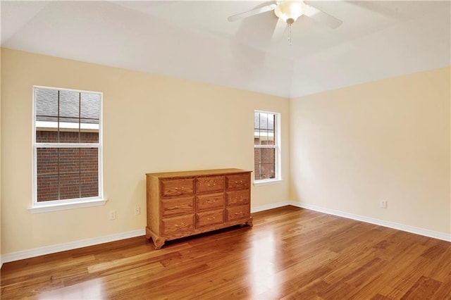 spare room with wood-type flooring, lofted ceiling, and ceiling fan