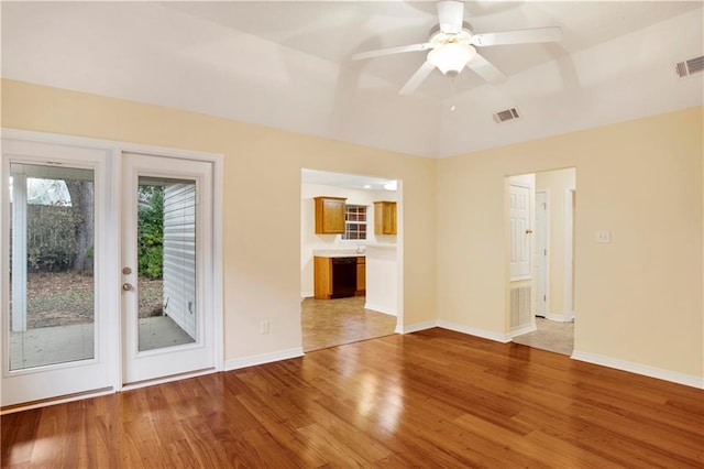 spare room featuring hardwood / wood-style flooring, vaulted ceiling, and ceiling fan