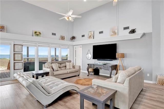 living area featuring visible vents, ceiling fan, and light wood finished floors