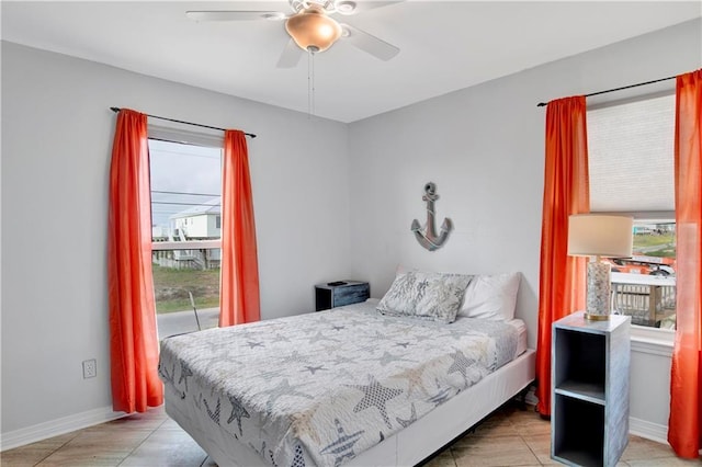 bedroom with access to outside, multiple windows, baseboards, and ceiling fan