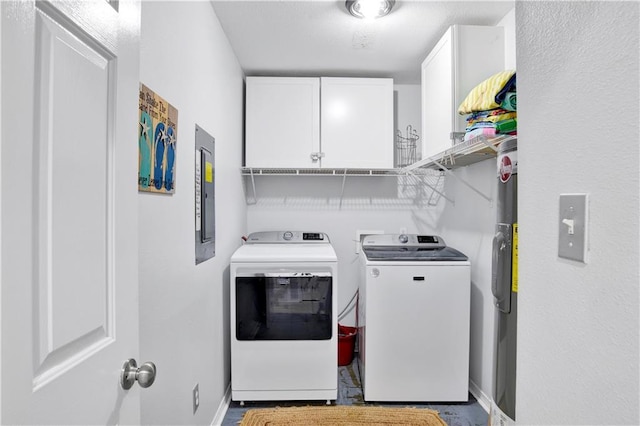 clothes washing area with electric panel, cabinet space, baseboards, and separate washer and dryer