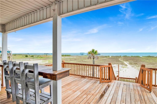 wooden deck with a beach view and a water view