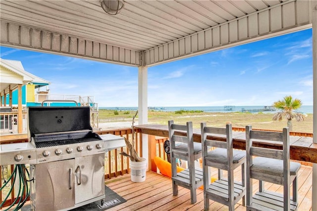 wooden deck featuring a view of the beach and a water view